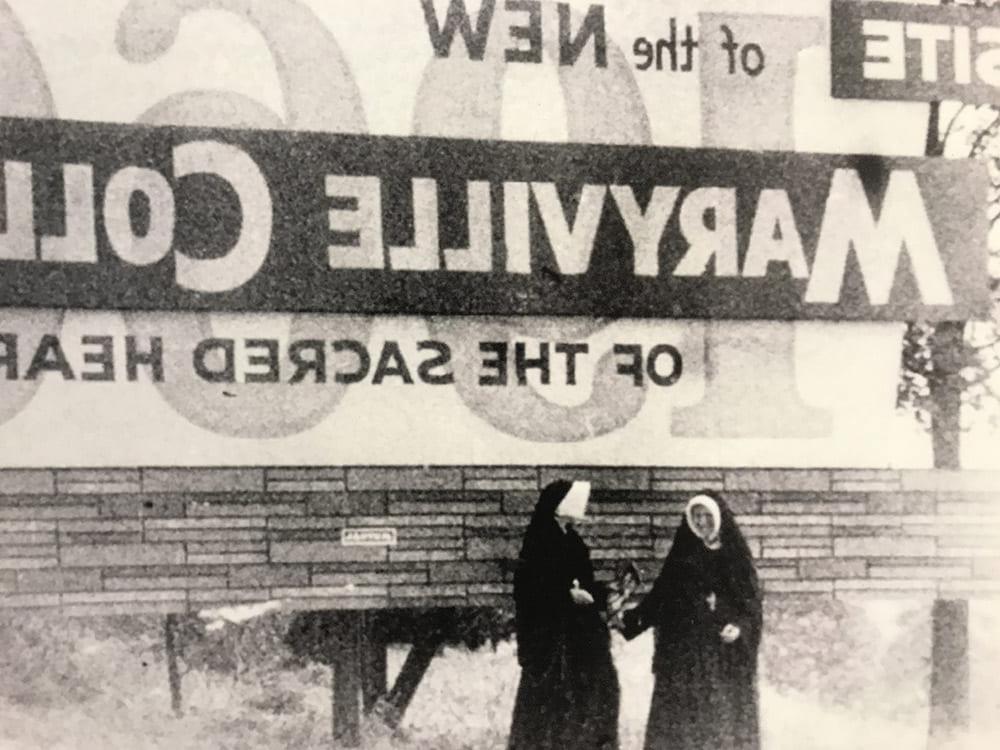 Two Sisters standing in front of sign